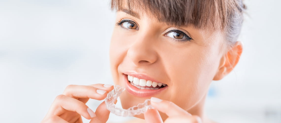 mujer con ataches de invisalign